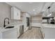 Modern kitchen with white cabinetry, stainless steel appliances, a large island, and tile backsplash at 11935 Riverhills Dr, Temple Terrace, FL 33617