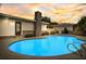 Bright blue in-ground pool with a stone chimney and relaxing sunset views, perfect for outdoor enjoyment at 11935 Riverhills Dr, Temple Terrace, FL 33617