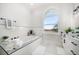 Sunlit bathroom with a soaking tub, decorative window, and modern fixtures at 124 Leeward Is, Clearwater Beach, FL 33767