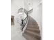 Elegant curved staircase features wood treads and a wrought iron railing at 124 Leeward Is, Clearwater Beach, FL 33767