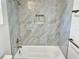 Bathroom features new tub and shower with marble-look tile surround at 16417 Lake Byrd Dr, Tampa, FL 33618