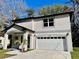 Two-story house boasting neutral paint, attached garage, well-maintained landscaping, and covered front porch at 16417 Lake Byrd Dr, Tampa, FL 33618