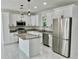 Modern kitchen featuring stainless steel appliances, granite countertops, and white cabinets with black hardware at 16417 Lake Byrd Dr, Tampa, FL 33618