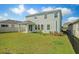 A landscaped backyard featuring a green lawn and the rear view of a two-story home at 16631 Mooner Plank Cir Cir, Wimauma, FL 33598