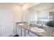 Bathroom featuring double vanity, granite countertop, large mirror, and walk-in shower at 16631 Mooner Plank Cir Cir, Wimauma, FL 33598