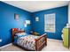 Bedroom featuring a twin bed, bright blue walls, neutral carpet, and lots of natural light at 16631 Mooner Plank Cir Cir, Wimauma, FL 33598