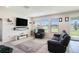 Comfortable living room with tile flooring, a large sofa, and bright natural light at 16631 Mooner Plank Cir Cir, Wimauma, FL 33598