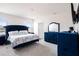 Spacious main bedroom featuring tufted blue furniture, neutral carpet, and bright natural light at 16631 Mooner Plank Cir Cir, Wimauma, FL 33598