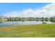 Scenic view of a tranquil pond reflecting nearby homes under a partly cloudy blue sky at 16631 Mooner Plank Cir Cir, Wimauma, FL 33598