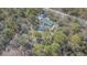 Aerial view of a serene backyard with a swimming pool, fire pit, and green lawn at 17480 Nuthatch Rd, Weeki Wachee, FL 34614