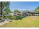 Backyard featuring a fire pit, outdoor seating, lush grass, and a screened-in pool in the distance at 17480 Nuthatch Rd, Weeki Wachee, FL 34614