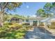 Single story home with a screened in porch, adjacent to a covered carport at 17480 Nuthatch Rd, Weeki Wachee, FL 34614