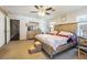 Main bedroom with a wooden bed frame, ceiling fan, carpeted floors and bedside tables at 17480 Nuthatch Rd, Weeki Wachee, FL 34614