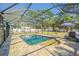 Screened-in pool area with a pool, a shed, patio furniture, and a well-maintained brick surround at 17480 Nuthatch Rd, Weeki Wachee, FL 34614