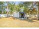 Outdoor shed with a garage door and attached workshop, surrounded by trees and a white fence at 17480 Nuthatch Rd, Weeki Wachee, FL 34614