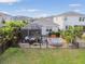 Aerial view of backyard featuring a screened-in lanai, lounge area, and well-maintained lawn at 17628 Breakaway St, Land O Lakes, FL 34638