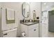 This bathroom features a gray countertop, black hardware, and a view of the kitchen through a doorway at 17628 Breakaway St, Land O Lakes, FL 34638