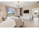 Bright bedroom with light wood floors, modern lighting fixture, and a view of the pool through the window at 17628 Breakaway St, Land O Lakes, FL 34638