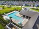 Aerial view of the community pool features sun umbrellas, seating, palm trees, and a covered pavilion at 17628 Breakaway St, Land O Lakes, FL 34638