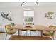 Dining room with wooden table, stylish olive colored chairs and bench illuminated by a modern chandelier at 17628 Breakaway St, Land O Lakes, FL 34638