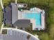 Aerial view of the community pool with lounge chairs and umbrellas adjacent to parking lot at 17628 Breakaway St, Land O Lakes, FL 34638