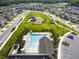 Aerial view of community pool with lounge chairs, umbrellas and neighborhood playground at 17628 Breakaway St, Land O Lakes, FL 34638