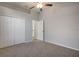 Bright bedroom featuring neutral carpeting, closet with double doors, and ceiling fan at 1814 Wood Trail St, Tarpon Springs, FL 34689