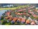 Aerial view of neighborhood featuring tiled roofs, community lake and manicured lawns at 18934 Avenue Biarritz, Lutz, FL 33558