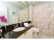 Bathroom with granite vanity, decorative shower curtain and marble floors at 18934 Avenue Biarritz, Lutz, FL 33558