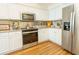 Updated kitchen featuring stainless appliances, white cabinets, and stylish backsplash at 18934 Avenue Biarritz, Lutz, FL 33558