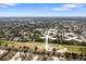 Aerial view of townhouses near a tranquil pond and lush green spaces, framed by city horizon at 2032 Sunset Meadow Dr, Clearwater, FL 33763