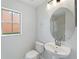 Bathroom featuring a pedestal sink, a round mirror, a toilet, a window and a tiled shower at 2032 Sunset Meadow Dr, Clearwater, FL 33763