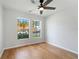 Bedroom featuring hardwood floors, a ceiling fan, and two windows with views of the neighborhood at 2032 Sunset Meadow Dr, Clearwater, FL 33763