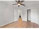 Clean bedroom featuring wood-look floors, ceiling fan, and double closet at 2032 Sunset Meadow Dr, Clearwater, FL 33763