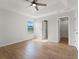 Bright bedroom features wood floors, tray ceiling with fan, and window view to the outside at 2032 Sunset Meadow Dr, Clearwater, FL 33763