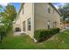 Two-story home exterior with sliding glass door, green lawn, and meticulously maintained shrubbery at 2032 Sunset Meadow Dr, Clearwater, FL 33763