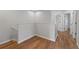 Hallway with wood floors, white walls, white railings, and doors leading to other rooms at 2032 Sunset Meadow Dr, Clearwater, FL 33763