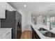 Kitchen featuring stone countertops, stainless steel sink and stainless steel refrigerator at 2032 Sunset Meadow Dr, Clearwater, FL 33763