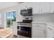 Modern kitchen featuring stainless steel appliances, white cabinets, subway tile backsplash, and a sliding glass door at 2032 Sunset Meadow Dr, Clearwater, FL 33763