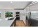 Bright kitchen with stainless steel appliances, a double sink island, and a sliding glass door to the backyard at 2032 Sunset Meadow Dr, Clearwater, FL 33763