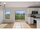 Kitchen with stainless steel appliances, white cabinets, subway tile backsplash, and a view to the outdoors at 2032 Sunset Meadow Dr, Clearwater, FL 33763