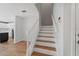 Staircase featuring white banister and wood steps, connecting to the kitchen and upper levels at 2032 Sunset Meadow Dr, Clearwater, FL 33763