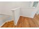 Wooden staircase with white walls, white railings, wood floors, and a well-lit ambiance at 2032 Sunset Meadow Dr, Clearwater, FL 33763