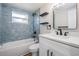 Stylish bathroom featuring updated blue tiles, a sleek vanity, and modern fixtures at 2043 Erin Dr, Holiday, FL 34690