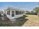 Exterior view of the home with a screened lanai and a partially fenced yard at 2043 Erin Dr, Holiday, FL 34690