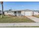 Charming single-story home with a front porch, well-maintained lawn and mature palm tree at 2043 Erin Dr, Holiday, FL 34690