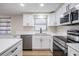 Modern kitchen featuring stainless steel appliances, white cabinetry and updated countertops at 2043 Erin Dr, Holiday, FL 34690