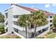 Exterior view of a condo building with balconies and palm trees at 2583 Countryside Blvd # 3212, Clearwater, FL 33761