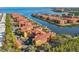 Stunning aerial view showcases waterfront condos with boat docks, surrounded by mature trees and blue skies at 2717 Via Cipriani # 620A, Clearwater, FL 33764