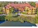 Aerial view of a well-maintained condo building with lush landscaping, red tiled roof, and mature trees at 2717 Via Cipriani # 620A, Clearwater, FL 33764